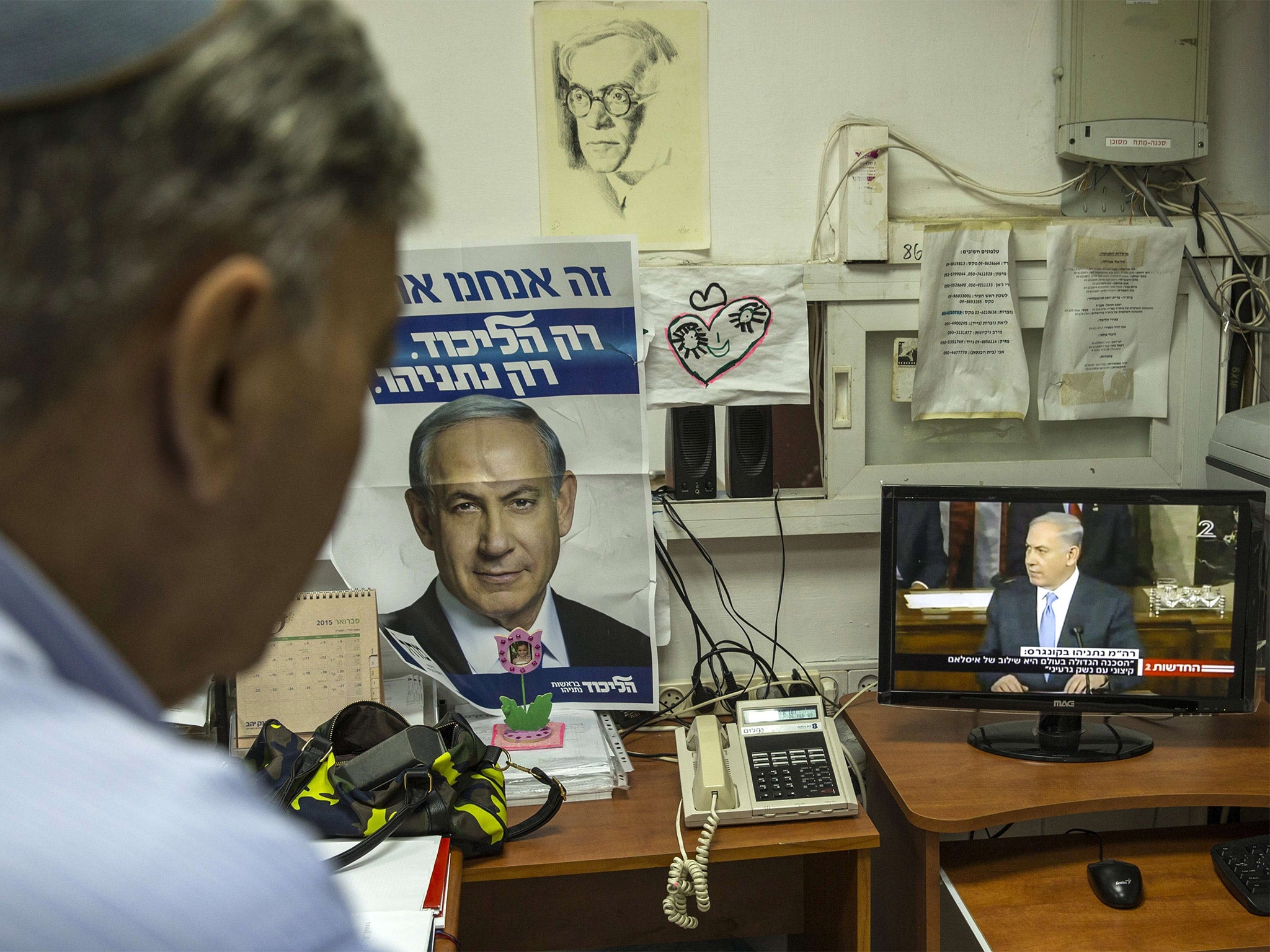 An Israeli man watches Prime Minister Benjamin Netanyahu addressing the US Congress, on a television in the Israeli city of Netanya