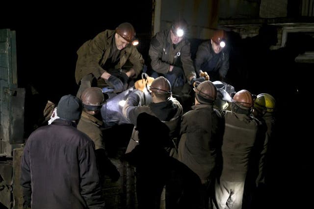 Ukrainian coal miners load the bodies of colleagues killed in this morning's explosion the Zasyadko mine in Donetsk, Ukraine
