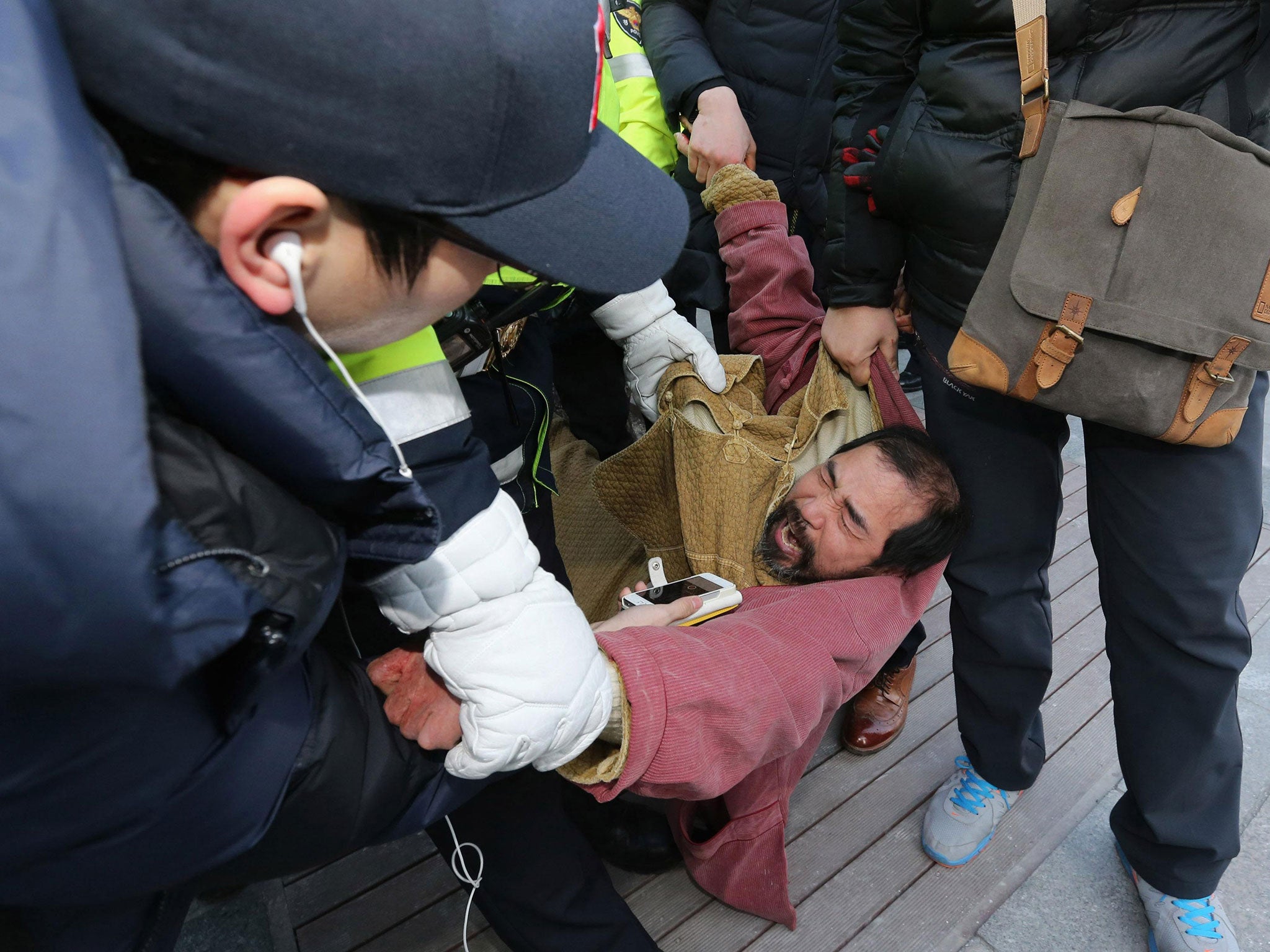 Security services detain the suspect, identified as 55-year-old Kim Ki-jong