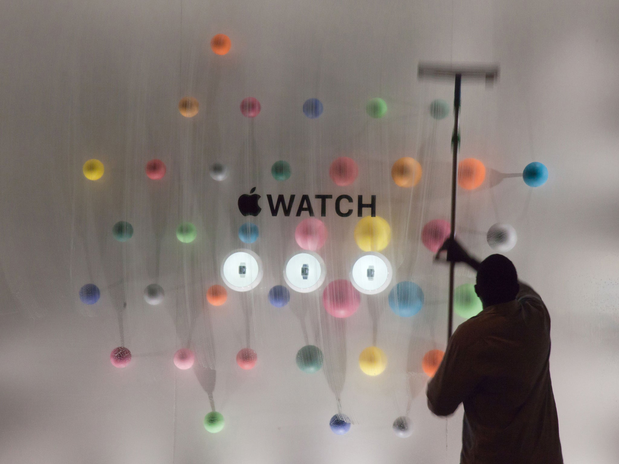 A man cleans the window displaying the Apple watch during the unveiling of the new and highly anticipated product at Saint-Honore street in Paris