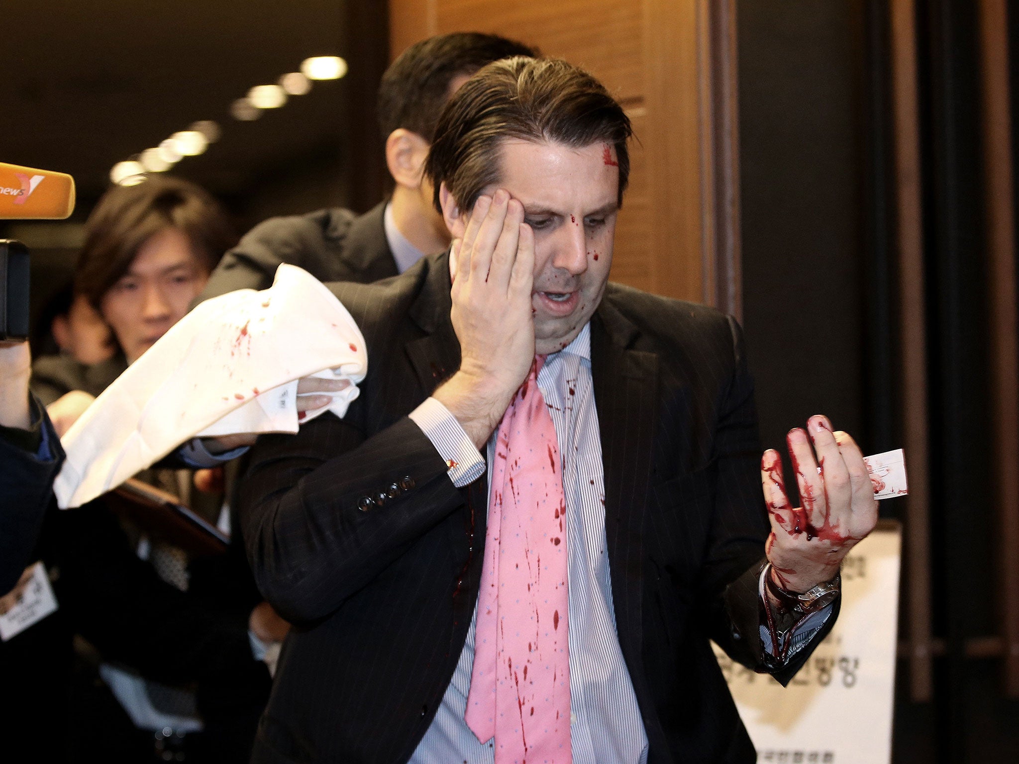 U.S. Ambassador to South Korea Mark Lippert leaves a lecture hall for hospital in Seoul, South Korea, Thursday, March 5, 2015 after being attacked