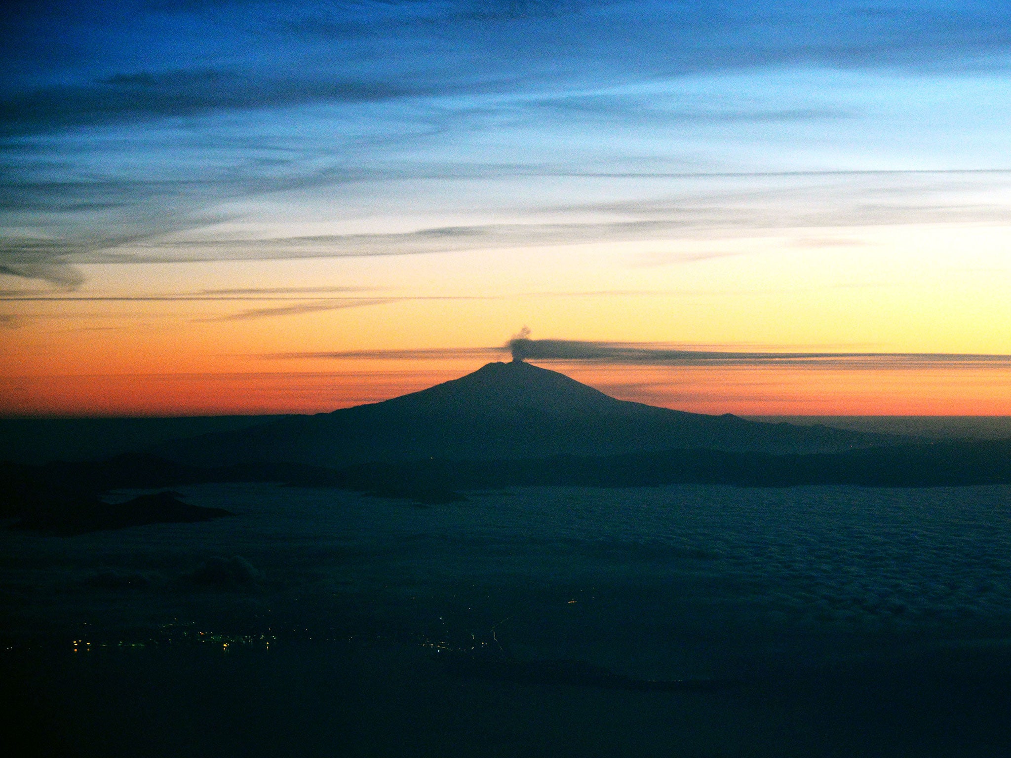 A view of Mount Etna spewing out smoke from its crater