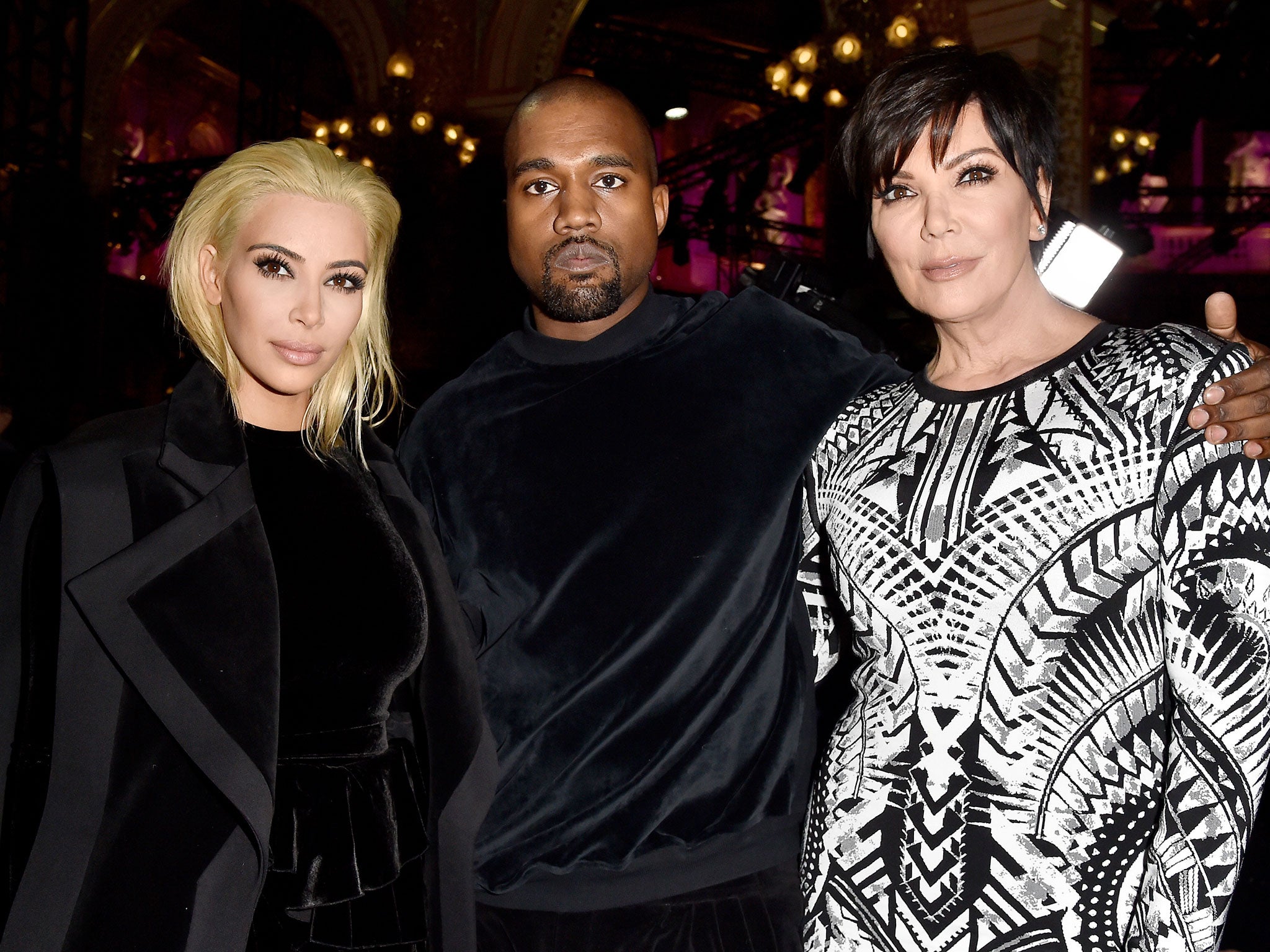 Kim Kardashian with her new blonde locks poses next to husband Kanye West and mother Kris Jenner