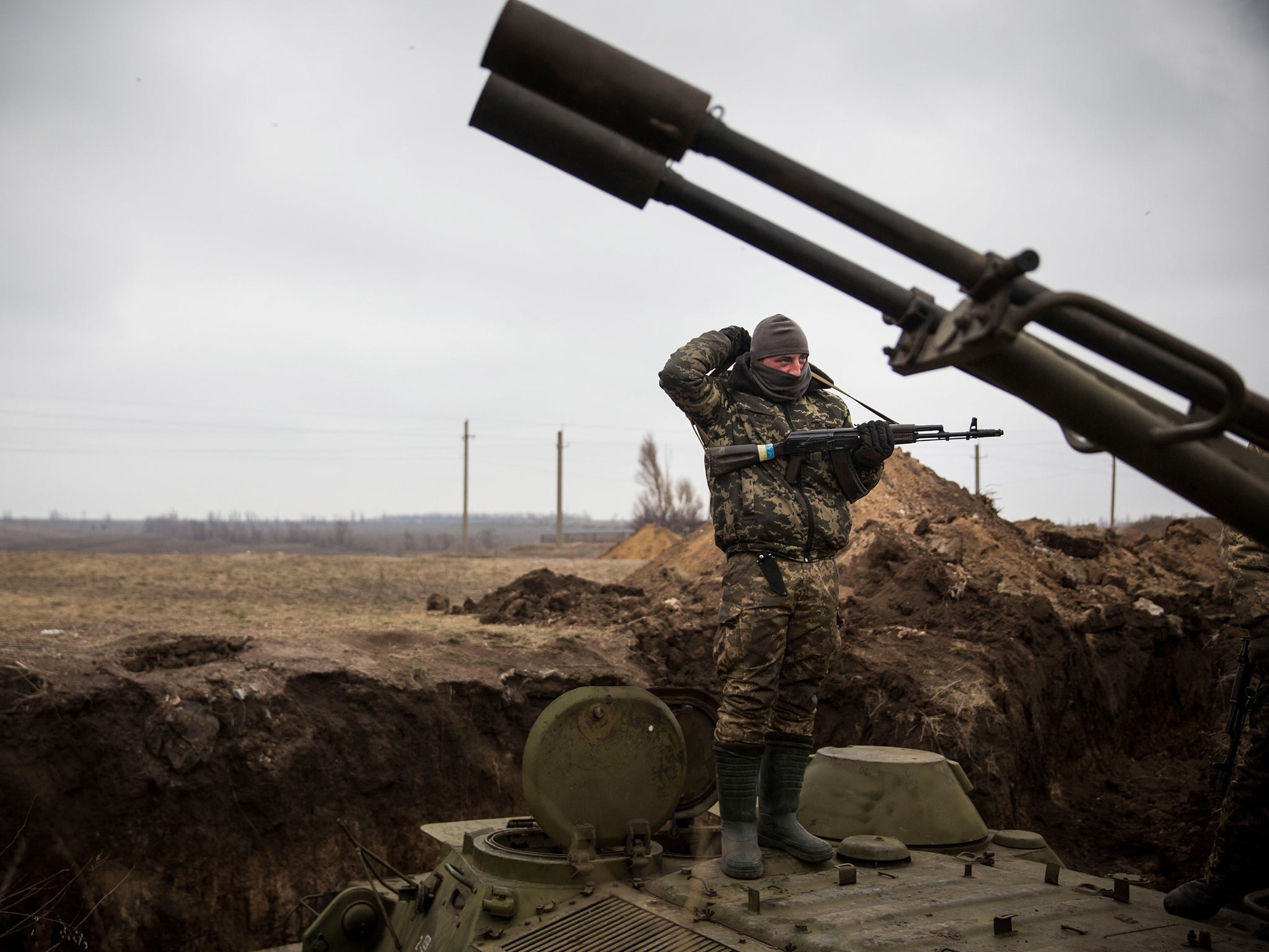 A Ukrainian soldier stands on top of an armored personal carrier near the front line of defense against pro-Russian separatists