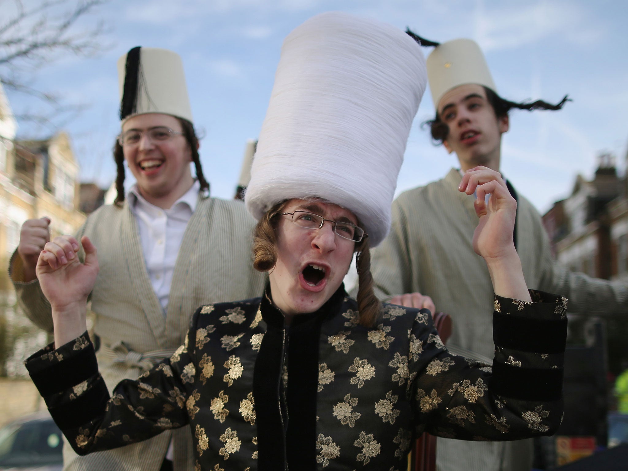 A group of Orthodox Jewish boys dance and sing outside the home of a local businessmen while collecting money for their school during the Jewish holiday of Purim on March 5, 2015 in London, England.