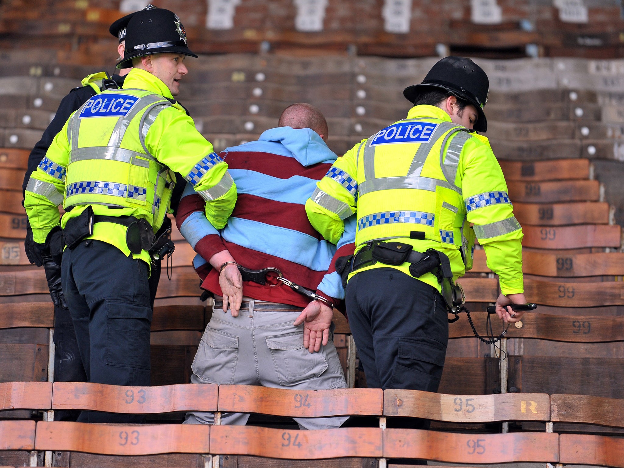 A Burnley fan is led away in handcuffs by police after
crowd trouble during a Premier League game in 2010