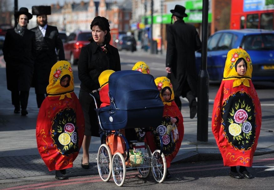 &#13;
Young girls dressed as Russian stacking dolls while out with their mother on Purim in north London (Getty)&#13;