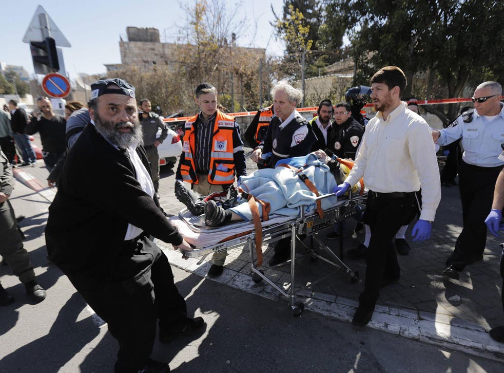 Israeli medics and a policeman evacuate an injured person from the scene of a March 2015 stabbing attack in Jerusalem