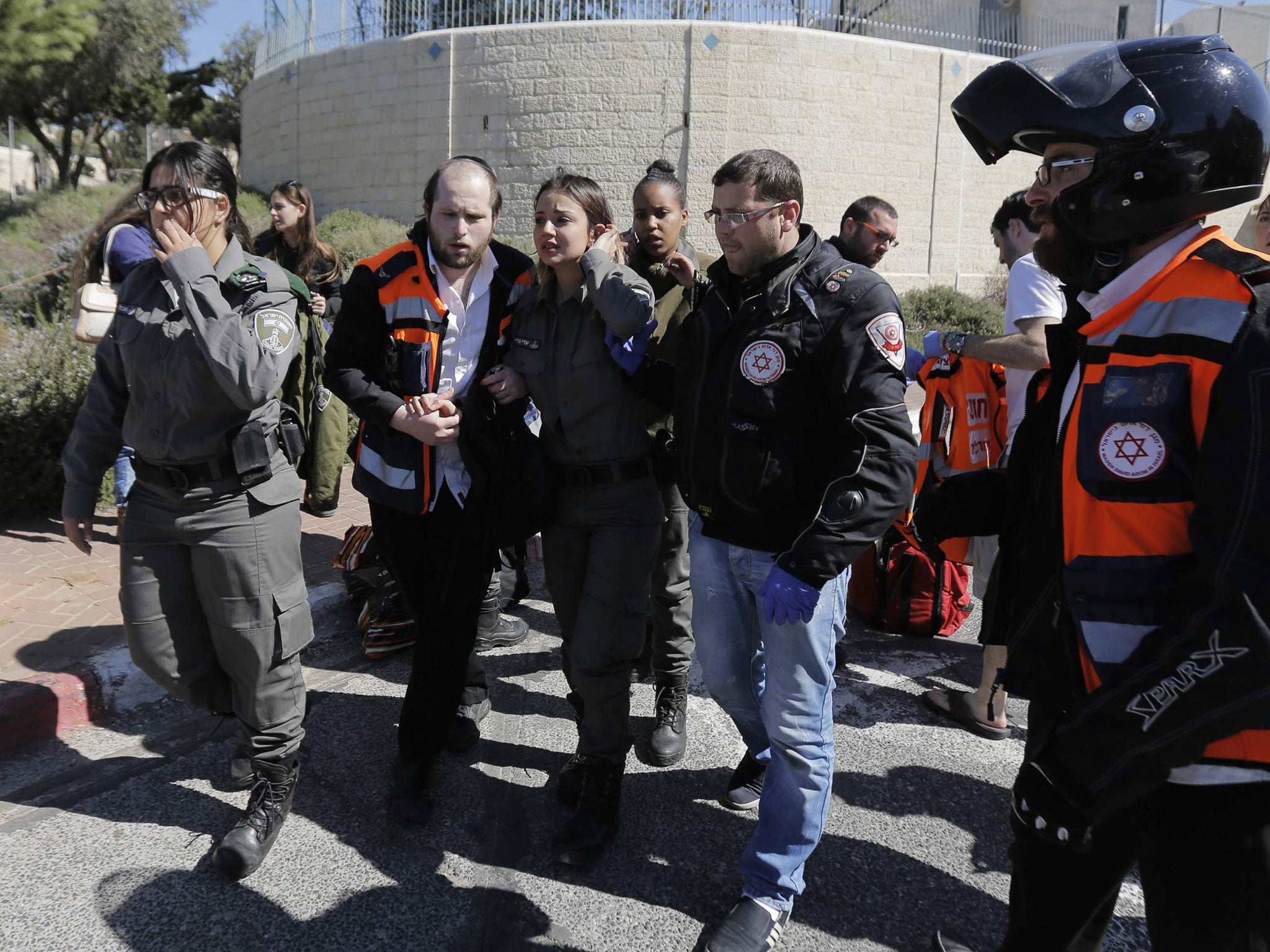 An Israeli border police woman speaks to a medic at the scene of an attack