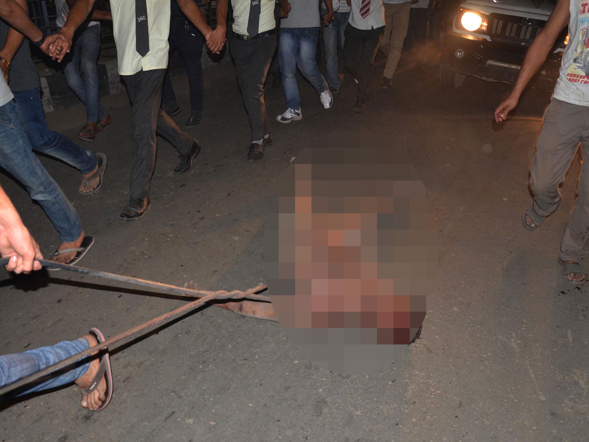 An alleged rapist is dragged on a street by a crowd of Indian men after he was pulled out of prison and beaten to death in Dimapur in the northeastern Indian state of Nagaland