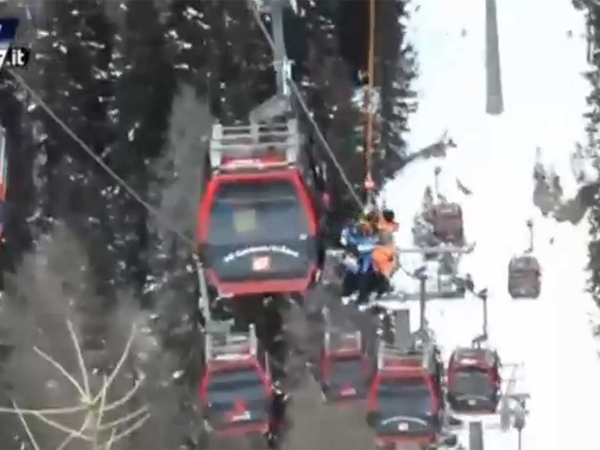 Skiers are lowered to safety after the cable car is stopped