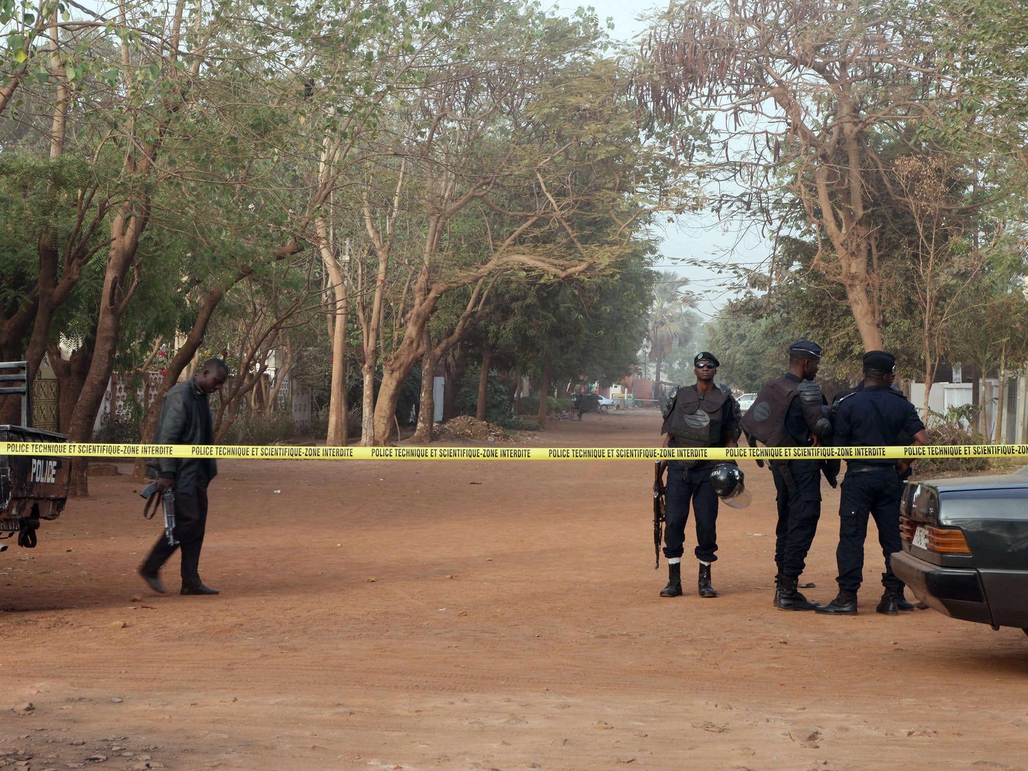 Policemen stand in a street near La Terrasse restaurant, in Bamako on March 7, 2015, after five people, including a French and a Belgian national