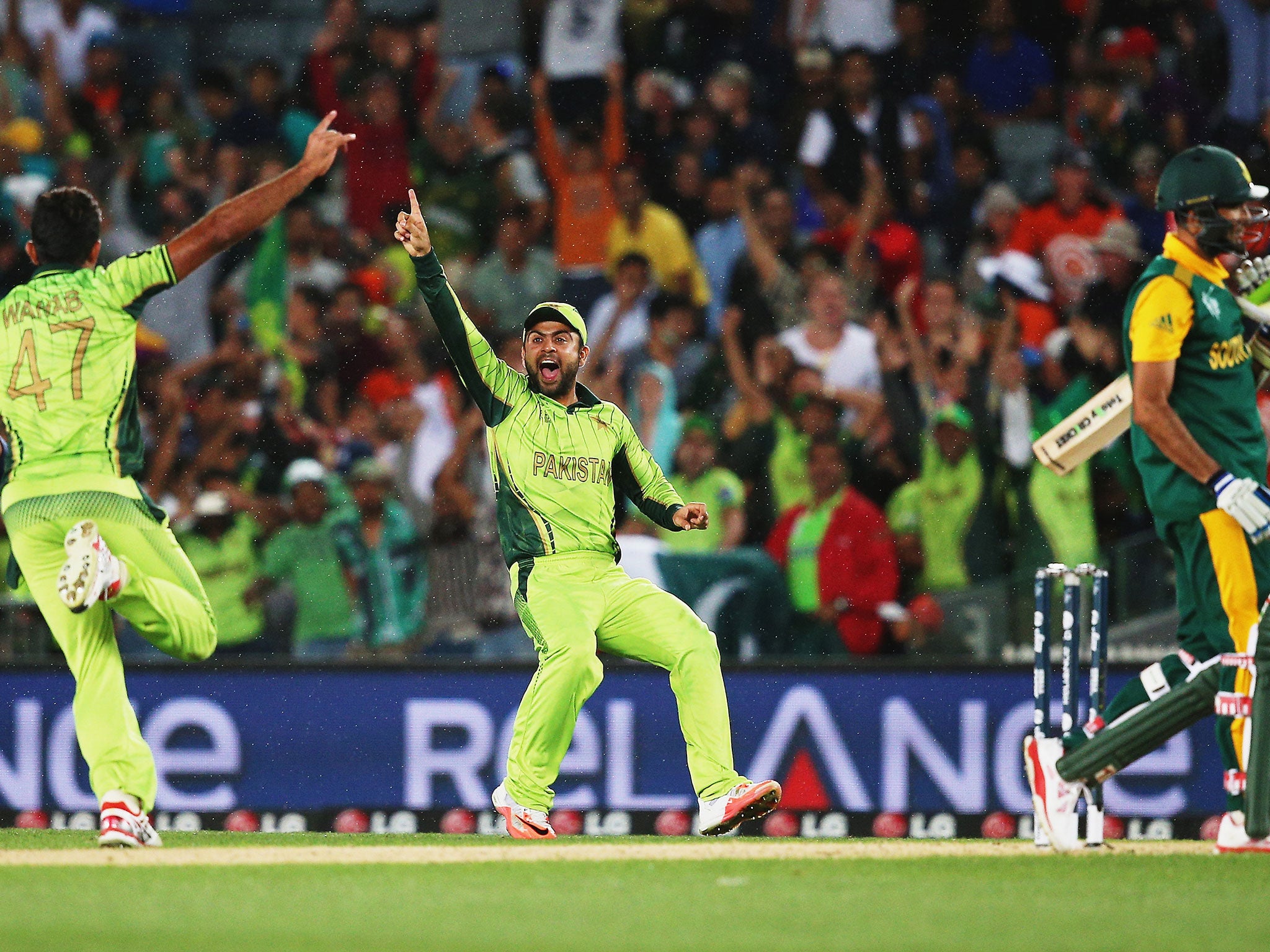 Wahab Riaz of Pakistan celebrates with Ahmad Shahzad of Pakistan after claiming the last wicket of Imran Tahir