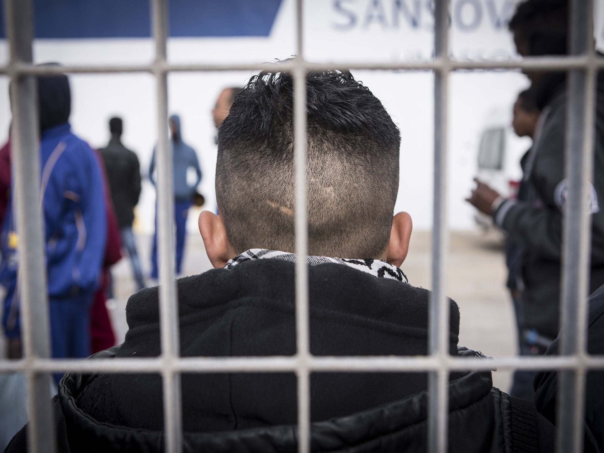 Yusuf, 17, waits along with 87 other unaccompanied children on the docks of Lampedusa, Italy
