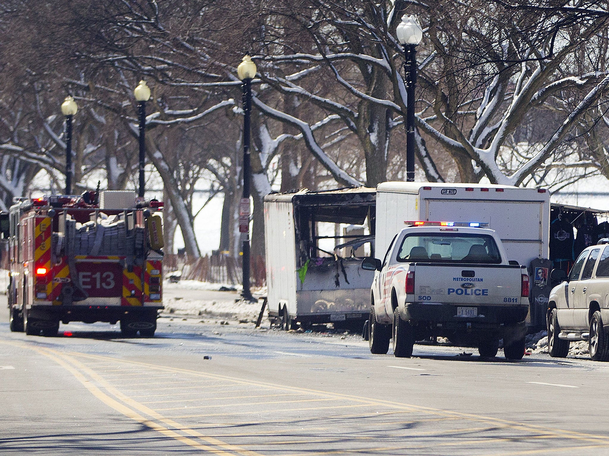Police and fire vehicles are seen along 15th street NW near the White House, near a vendor cart that caught on fire Saturday, March 7, 2015 in Washington.