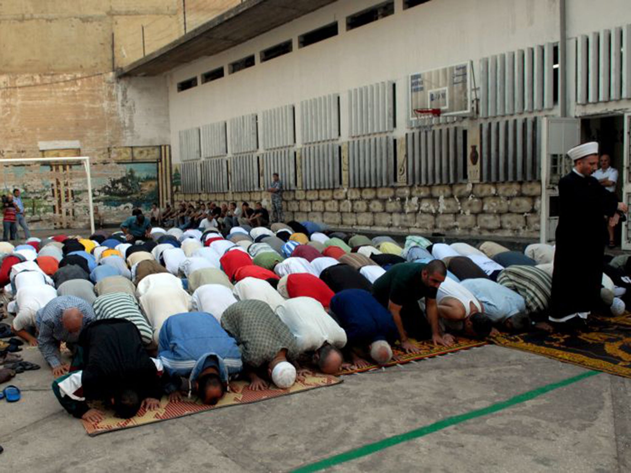 Muslim prisoners in the Roumieh prison pray in the exercise yard during the Eid al-Fitr prayers marking the end of Ramadan