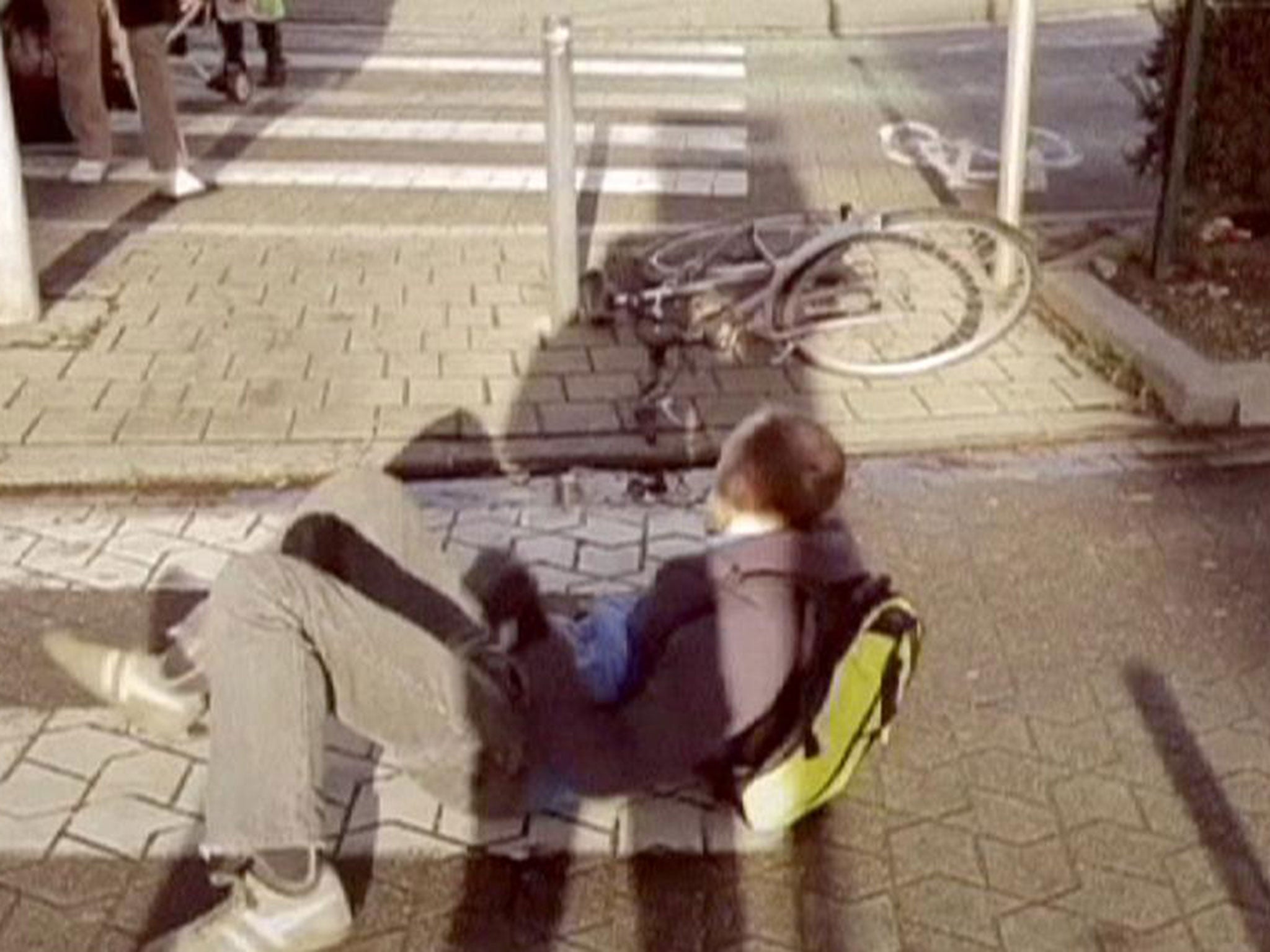 Cyclist tries to lift himself up after falling at a curb