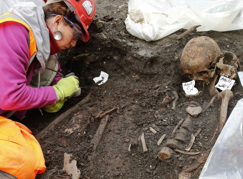 An archaeologist works near skeletons found in the Bedlam burial ground on the future site of a Crossrail ticket hall next to Liverpool Street Station in London March 6, 2015. Archaeologists have started excavating around 3,000 skeletons from the Bedlam b