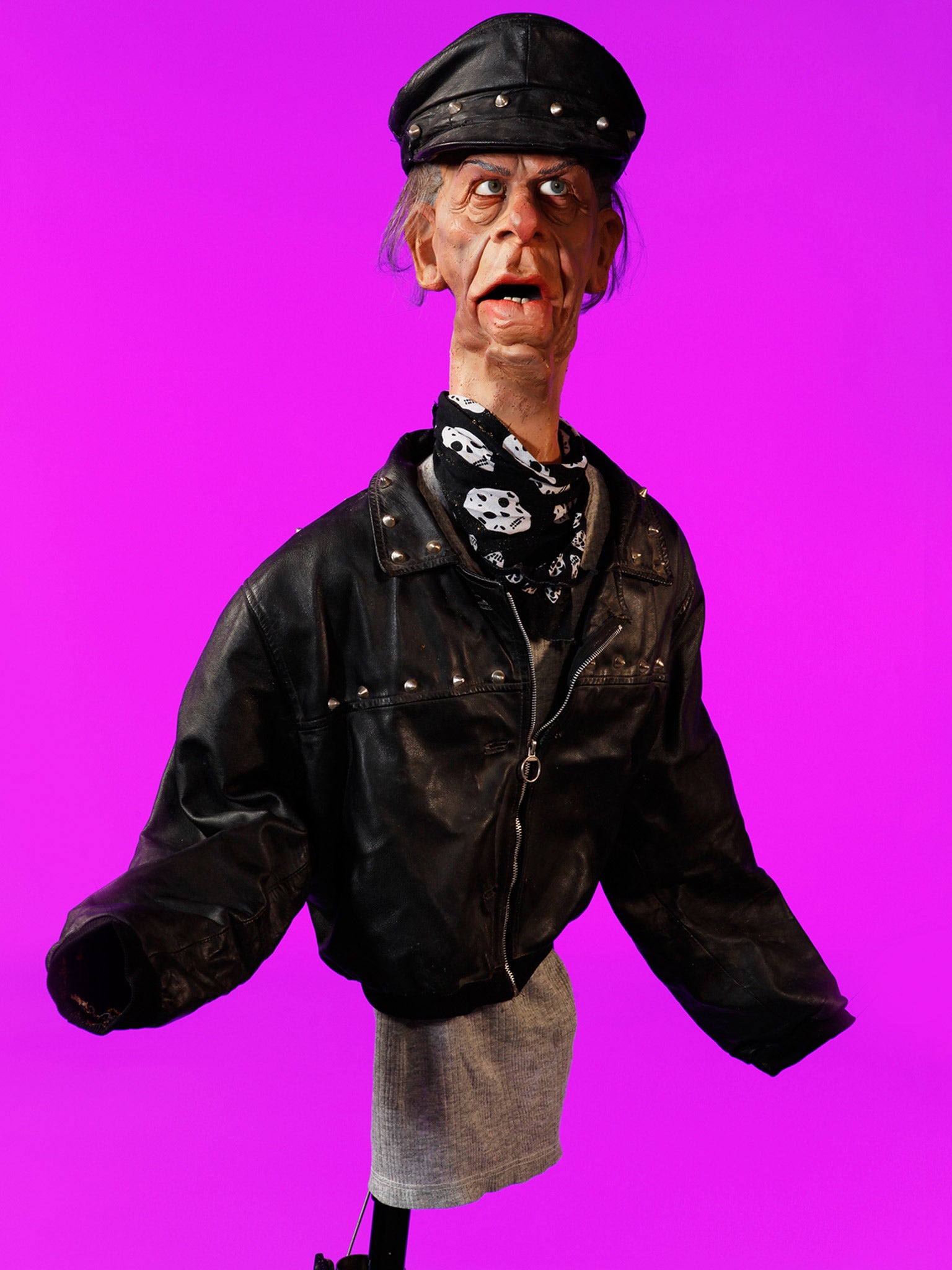 The vivid pink photograph of Norman Tebbit, who was portrayed in the show as a bully and a thug, shows him wearing a biker jacket and leather hat (Andrew Bruce &amp; Anna Fox)