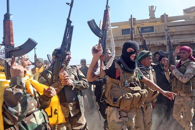 Iraqi pro-government fighters celebrate as they advance into Tikrit