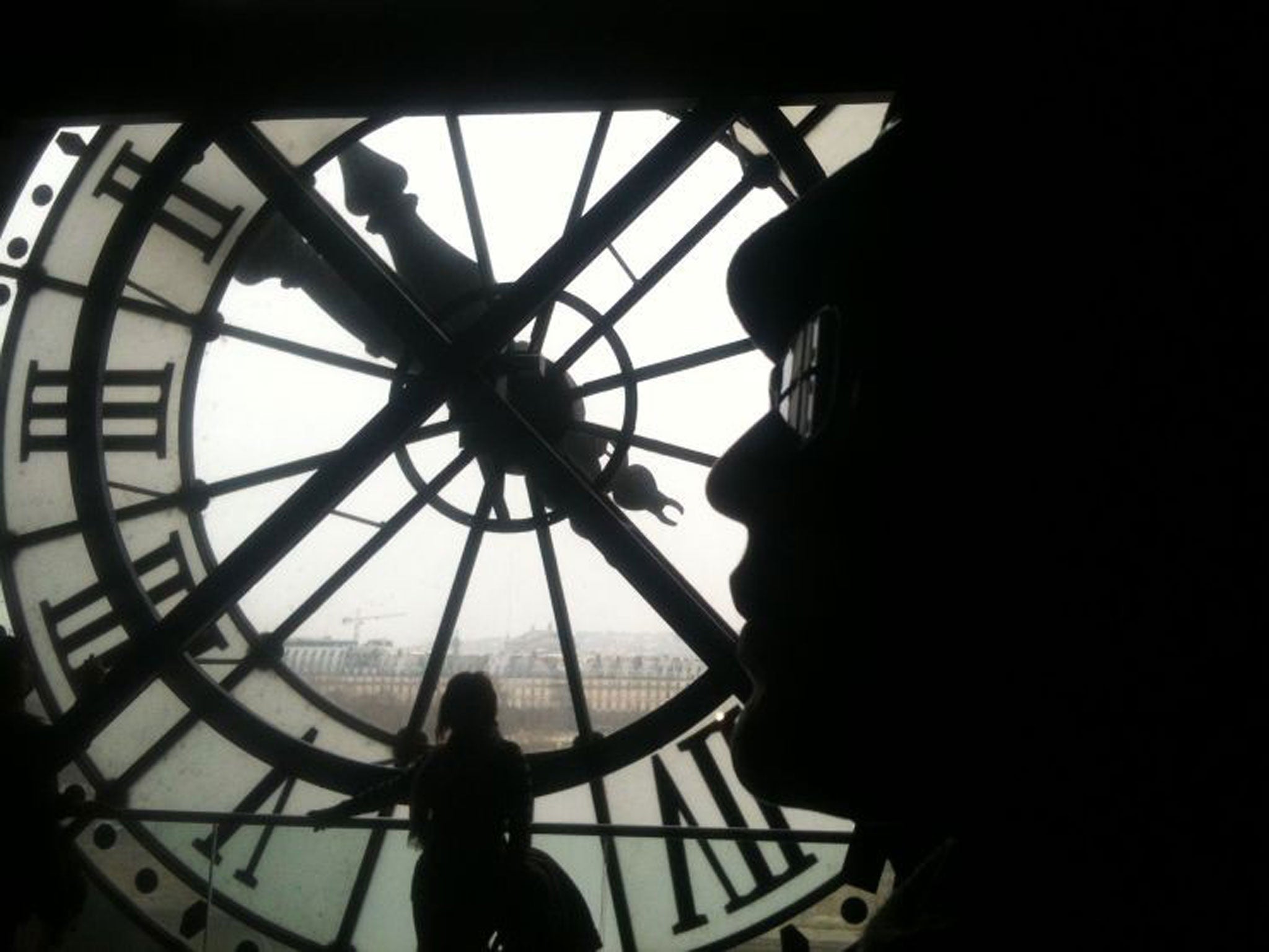 Behind the times: visitors to Paris's Musée d'Orsay admire the clock face, but where does it get the correct time from? (AFP/Getty)