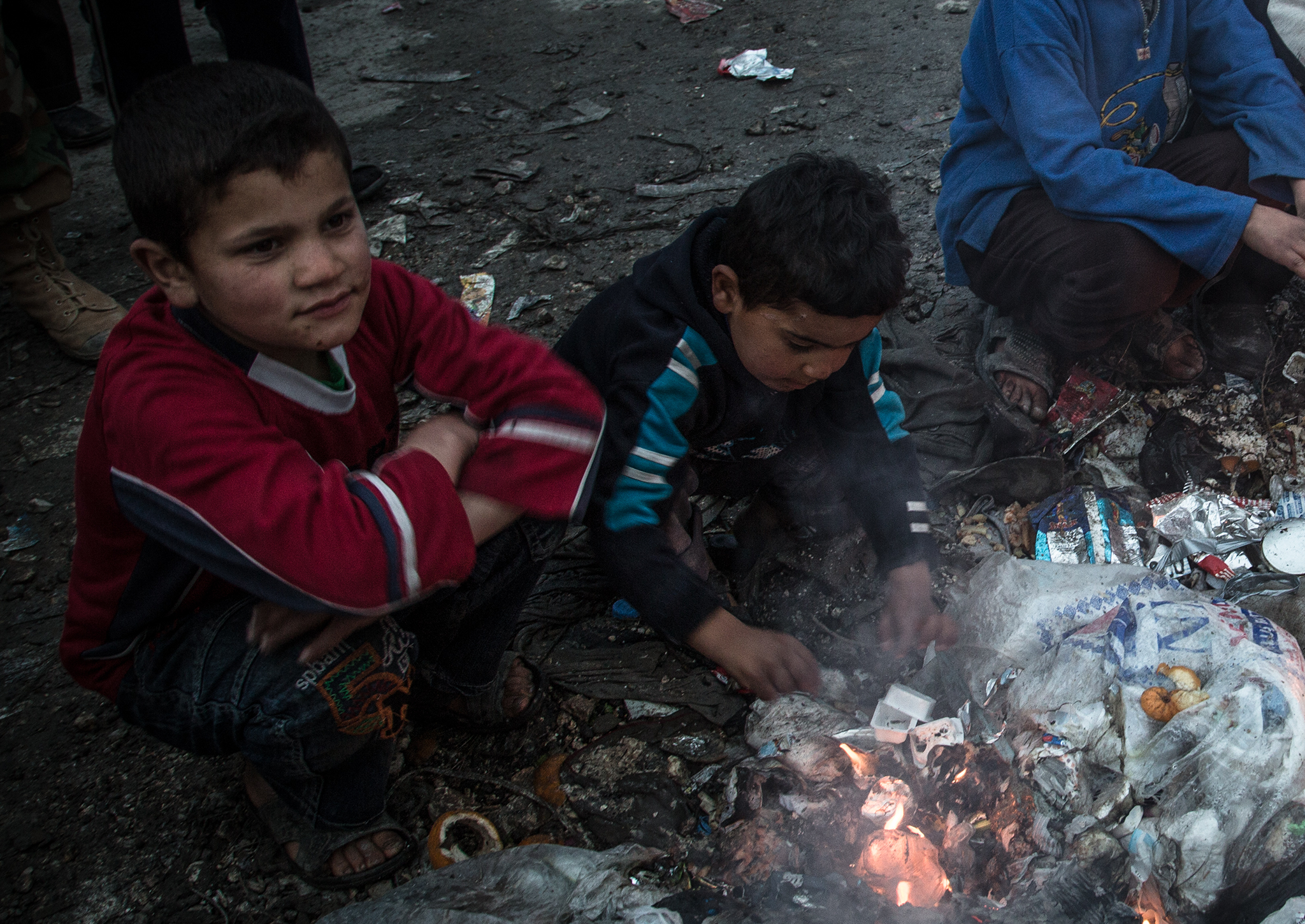 Syrian children try to keep warm in the Bab Al Hawa refugee camp near the Syria-Turkey border (Credit: Chris Huby)