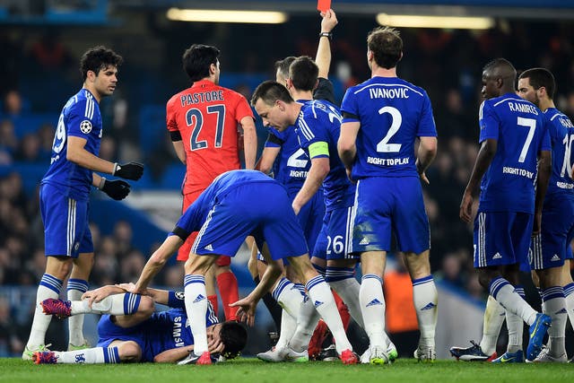 Chelsea players hound referee Bjorn Kuipers during their match with PSG
