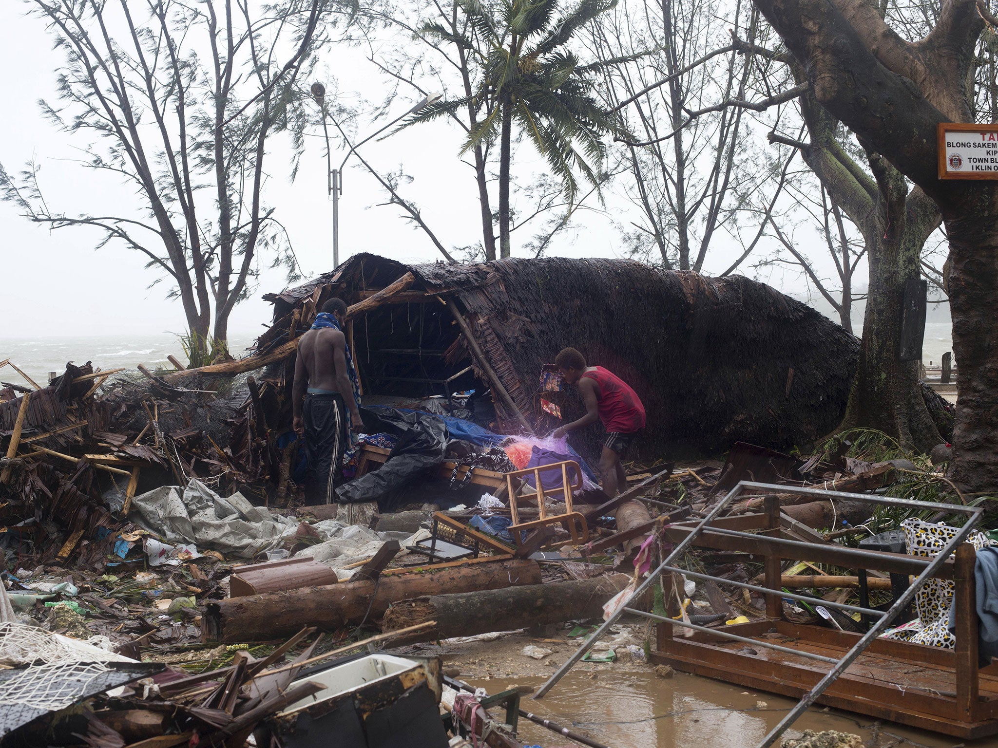 People scour through debris damaged and flung around in Port Vila, Vanuatu on Saturday