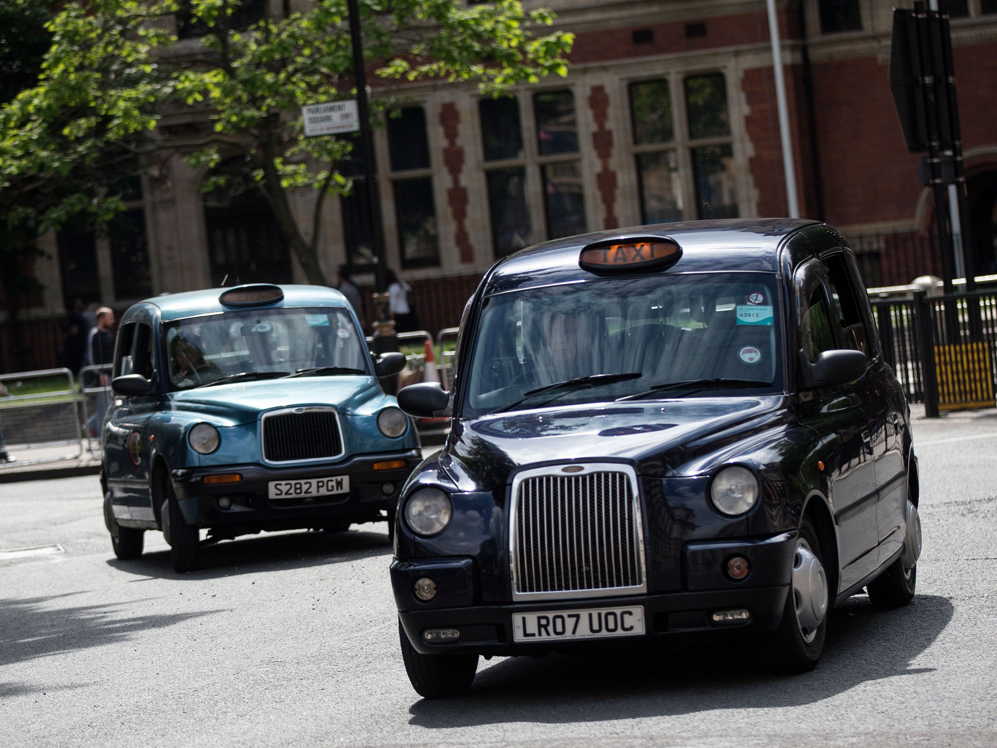 Taxis drive on the streets of Westminster on June 2, 2014 in London, England. The controversial mobile application 'Uber', which allows users to hail private-hire cars from any location, is opposed by established taxi drivers and currently serves more tha