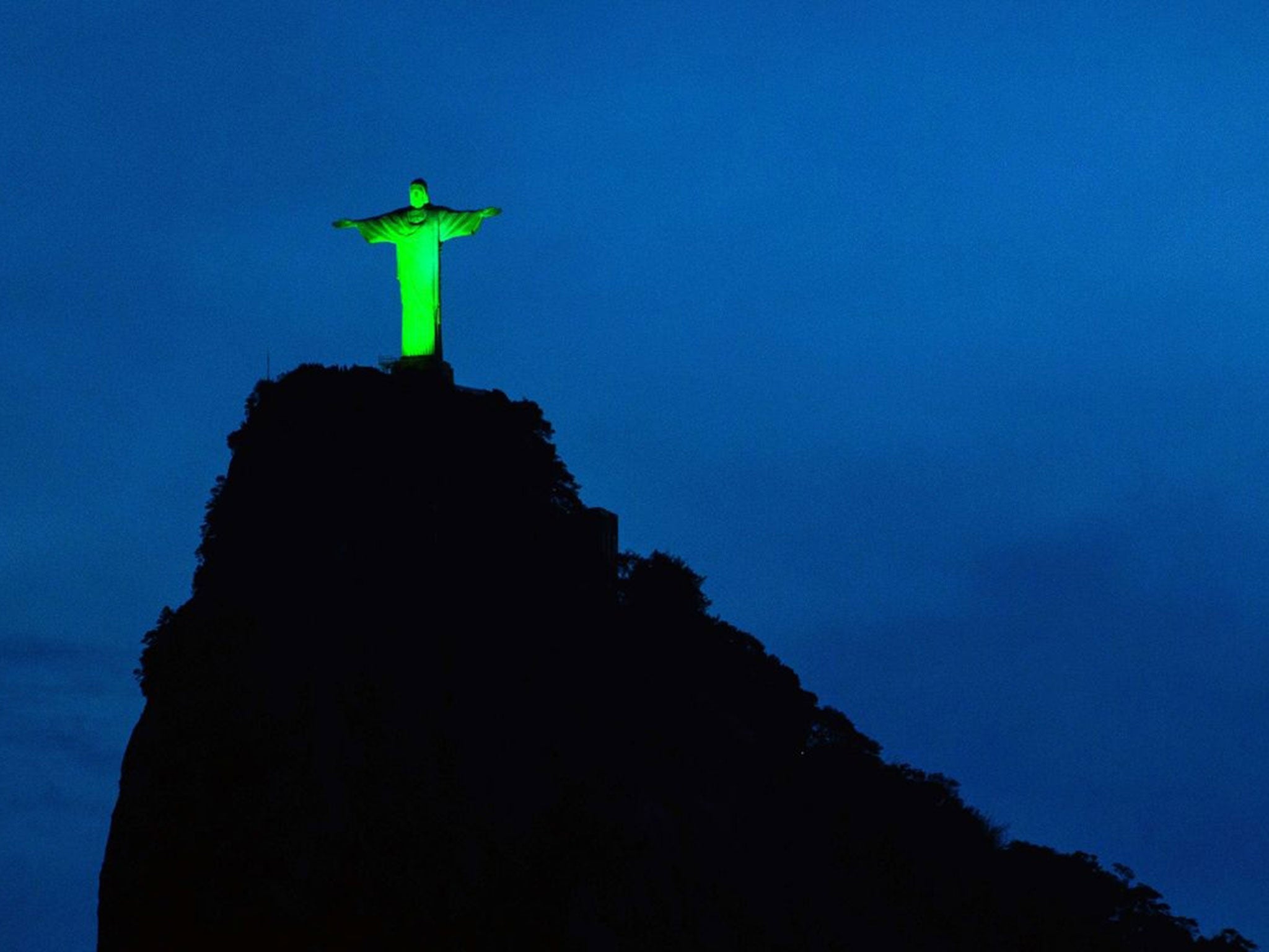 View of the statue of Christ the Redeemer illuminated in green to celebrate the upcoming Irish festivity of Saint Patrick's Day, atop Corcovado hill in Rio de Janeiro, Brazil, on March 15, 2015.