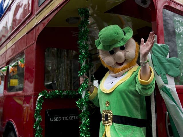 A woman dressed as a leprechaun, a fairy type in Irish folklore, waves from a London bus that is participating in the St. Patrick's Day Parade in London, Britain, 15 March 2015. St. Patrick's Day is a bank holiday in Ireland and North Ireland to honour Pa