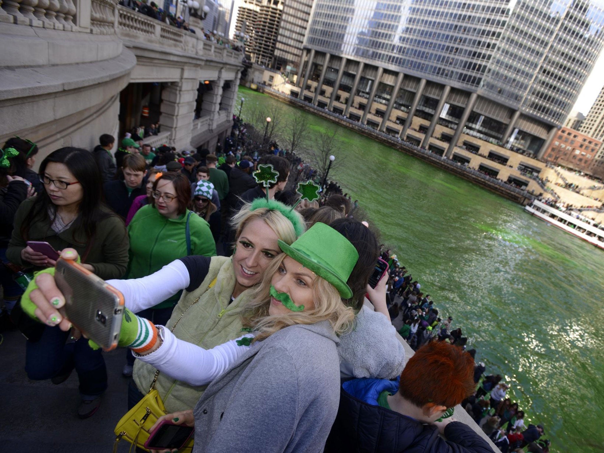 Alex Nowakowska left, and Joanna Puchlik right, both from Chicago, take a selfie after the Chicago River is dyed green for St. Patrick's Day.