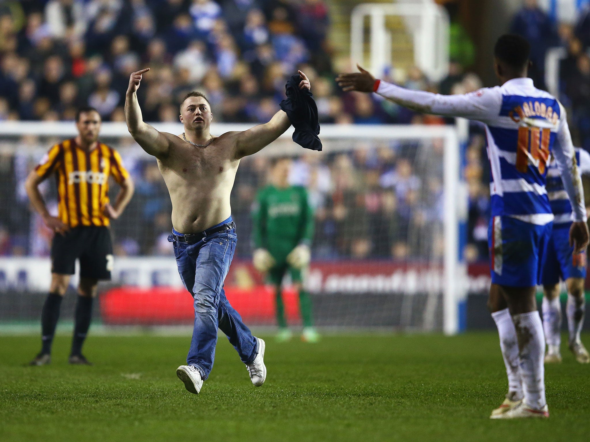 A shirtless pitch invader runs on to the pitch during Reading vs Bradford