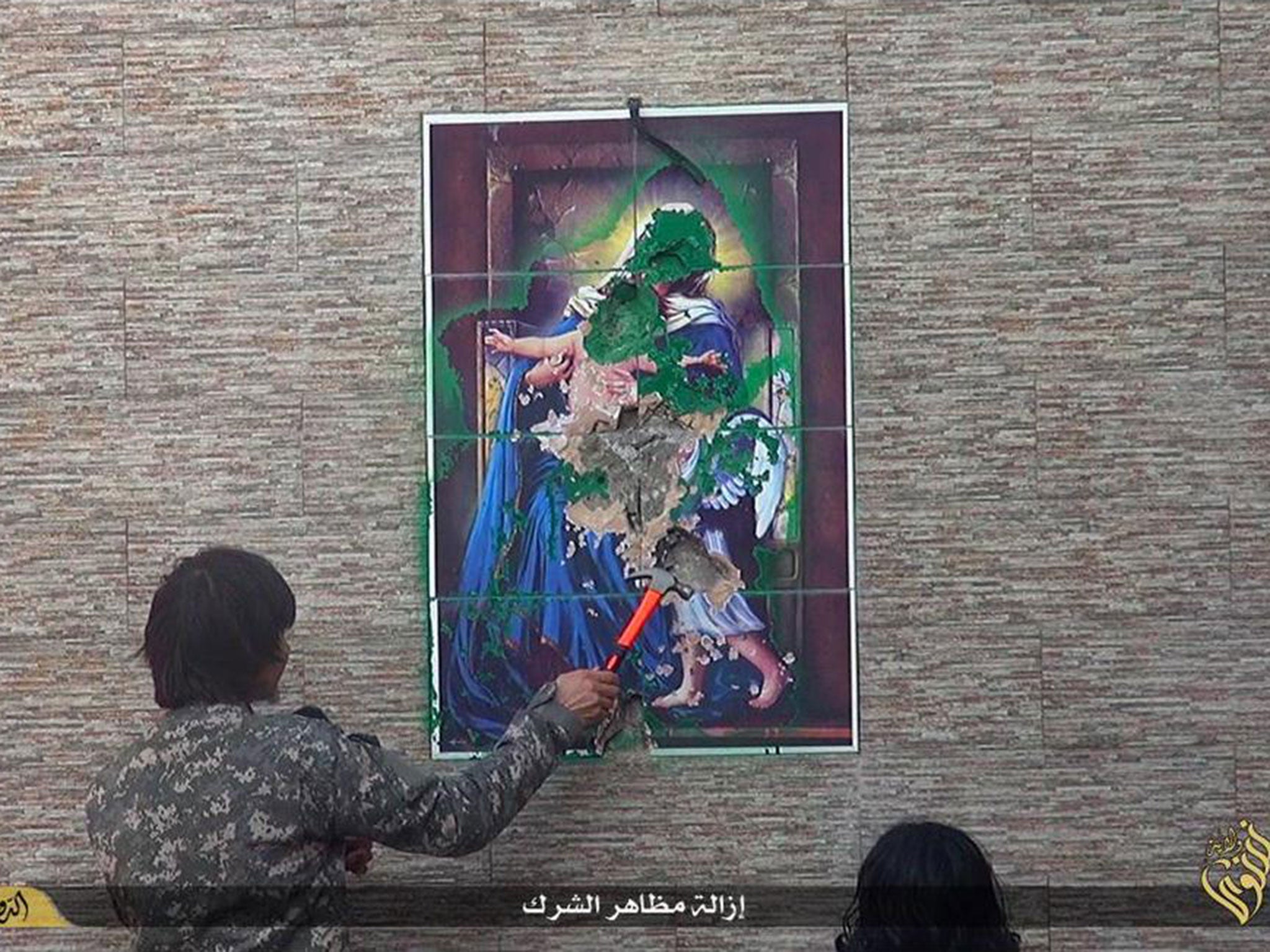 A militant destroys a statue of the Virgin Mary and baby Jesus