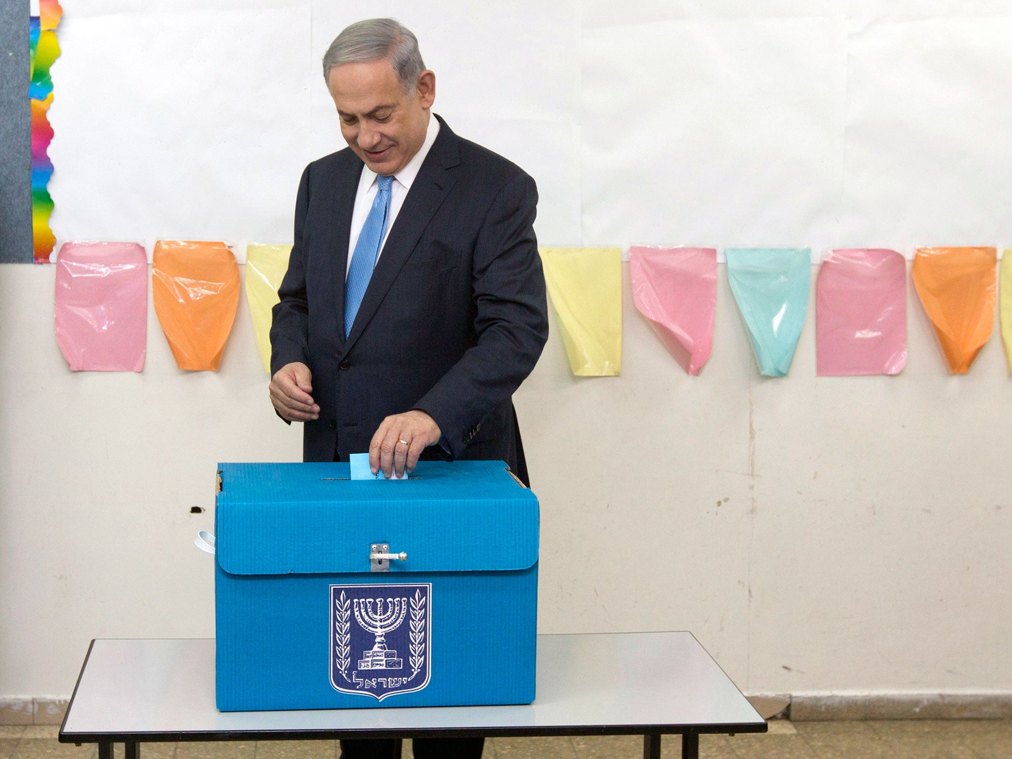 Israel's Prime Minister Benjamin Netanyahu casts his ballot for the parliamentary election at a polling station in Jerusalem