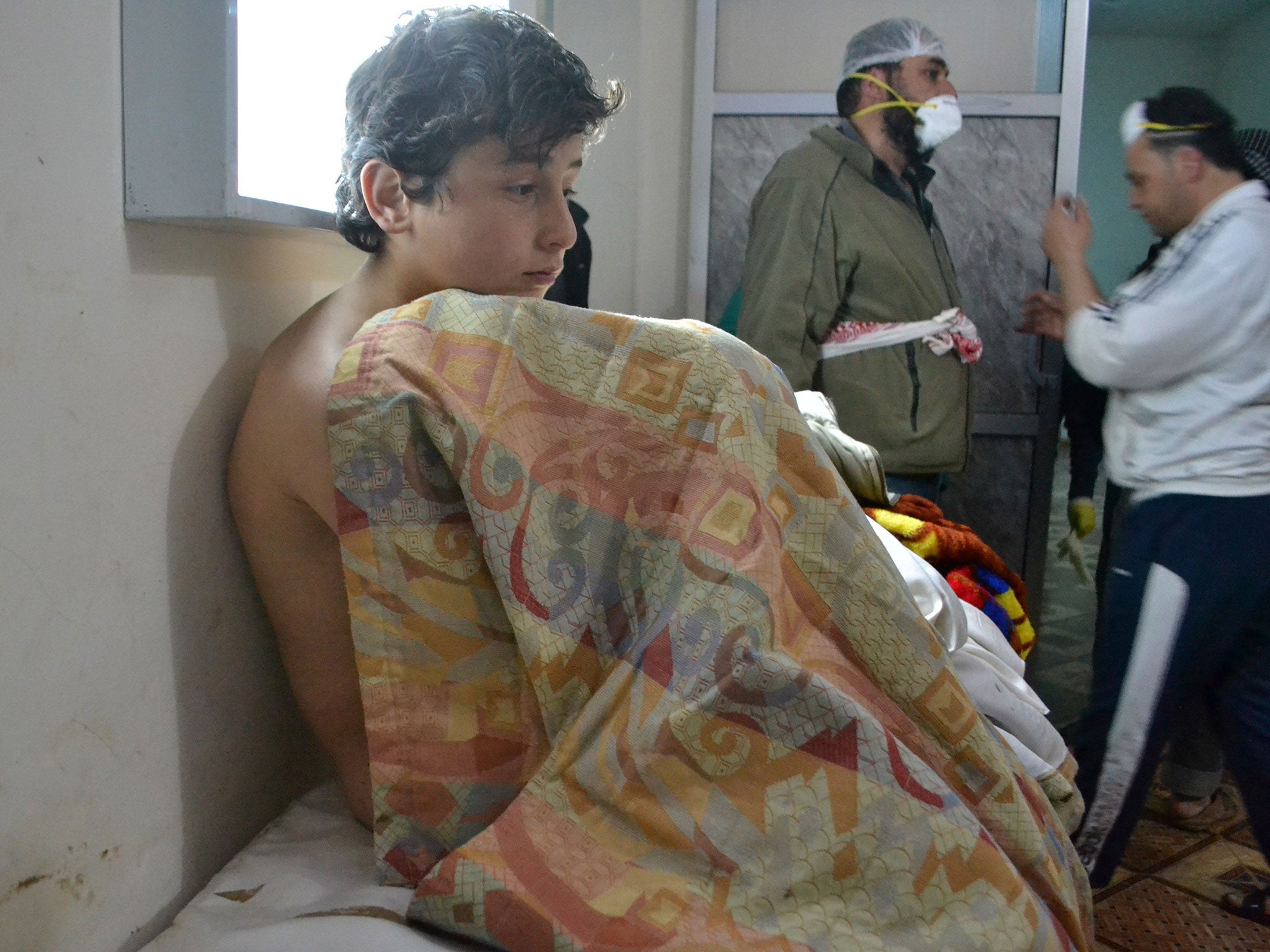 A young man sits on a bed on March 17, 2015 at a clinic in the village of Sarmin, southeast of Idlib, the capital of Syria's northwestern province of Idlib, following reports of suffocation cases related to an alleged regime gas attack in the area