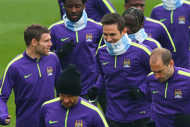 James Milner and Frank Lampard in discussion as they jog with team mates during a Manchester City training session