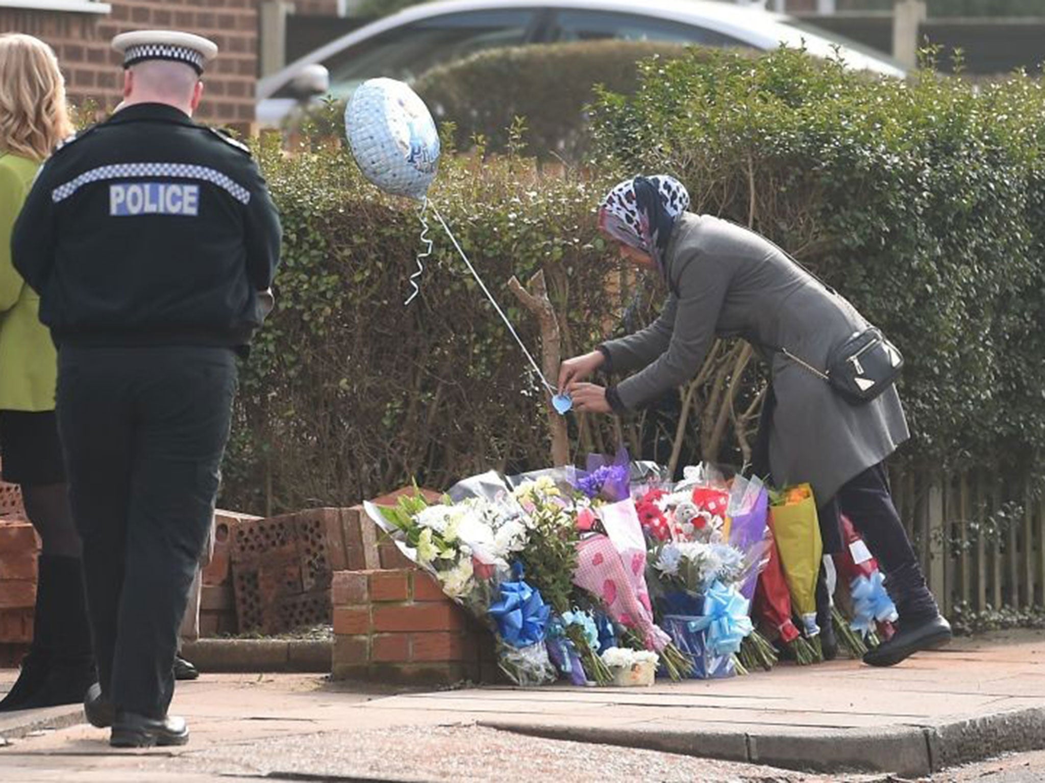 A woman lays flowers where Amaan Yaseen died