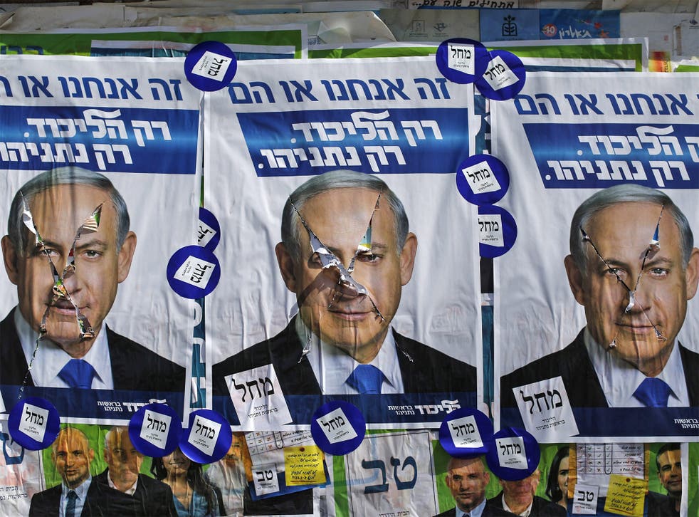 Vandalized posters of Israeli Prime Minister Benjamin Netanyahu near a polling station in the West Bank Jewish settlement of Kiryat Arba, near Hebron