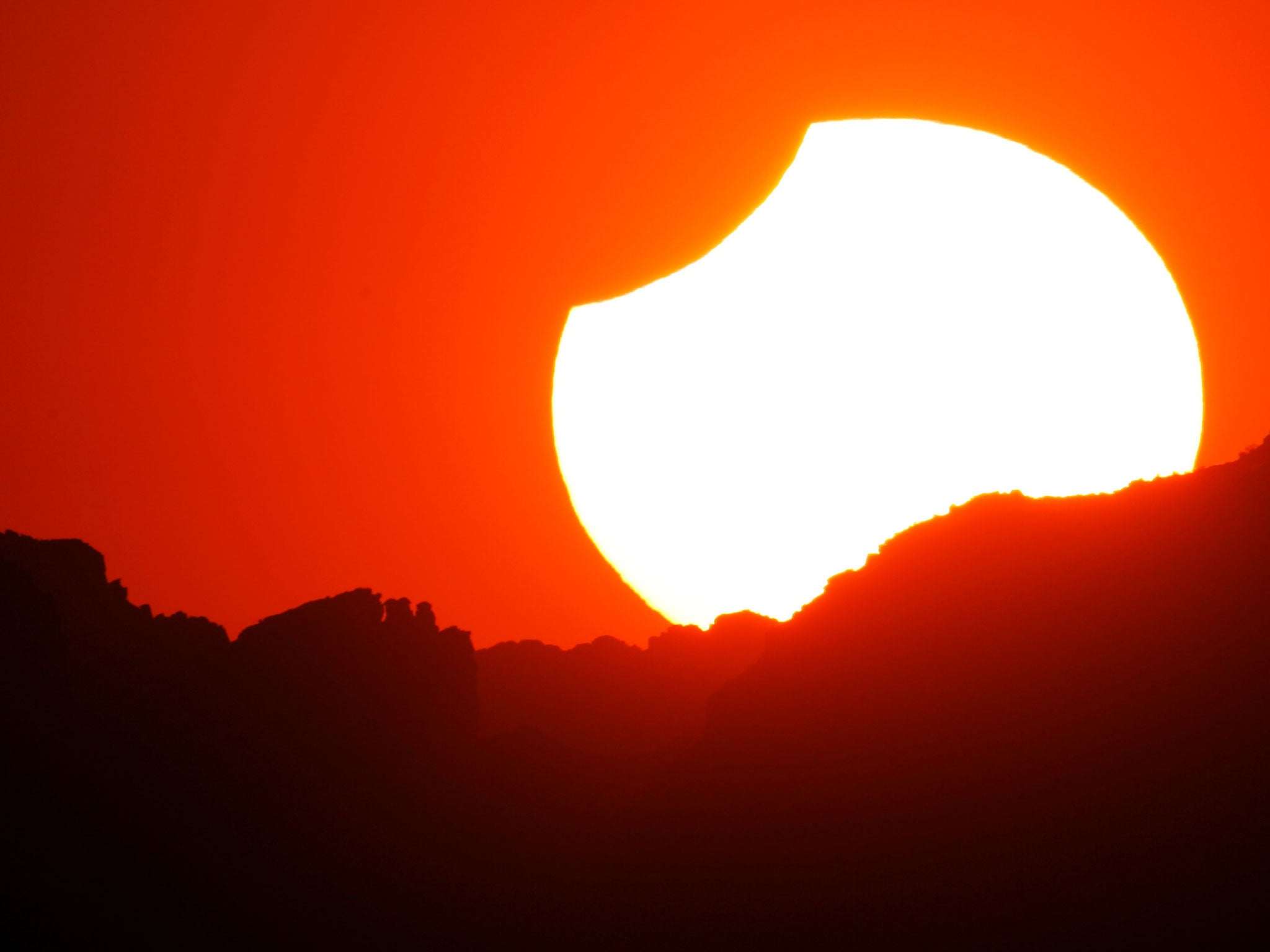A partial eclipse seen in USA as the sun sets in Grand Canyon National Park, Arizona
