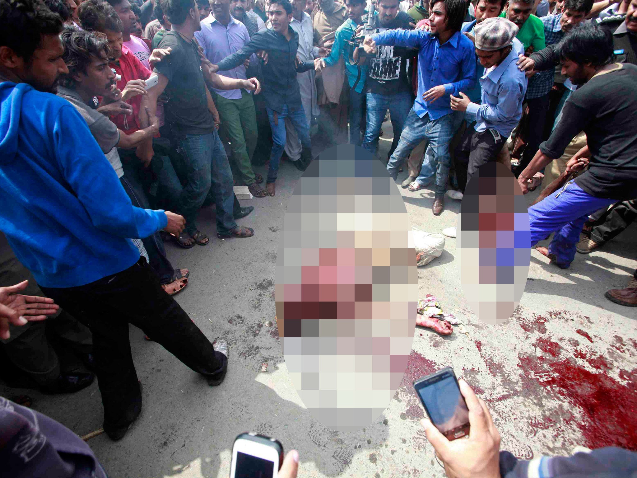 A crowd photograph and set fire to a man they suspect of being involved in a suicide attack on a church in Lahore