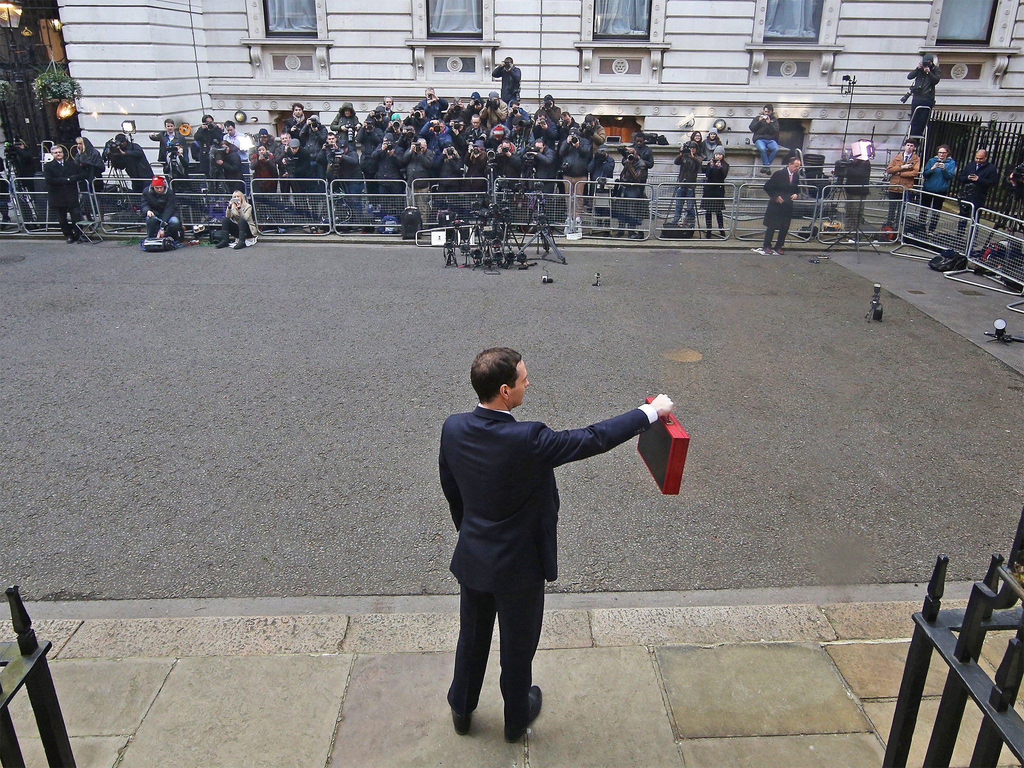 Chancellor of the Exchequer George Osborne holds his ministerial red box up to photographers as he stands outside number 11 Downing Street