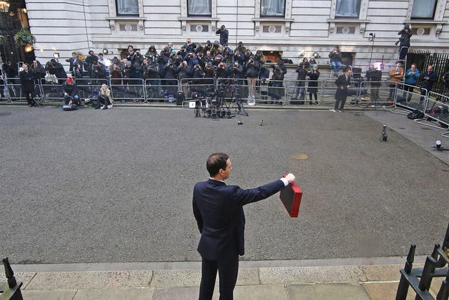 Chancellor of the Exchequer George Osborne holds his ministerial red box up to photographers as he stands outside number 11 Downing Street 