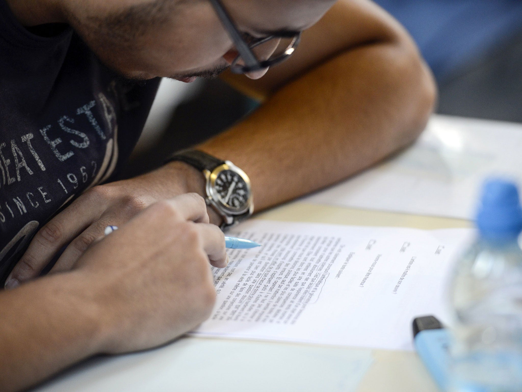 A French student works on the test of philosophy as he takes the baccalaureat exam (high school graduation exam) on June 16, 2014 at the Jacques Decour high school in Paris.