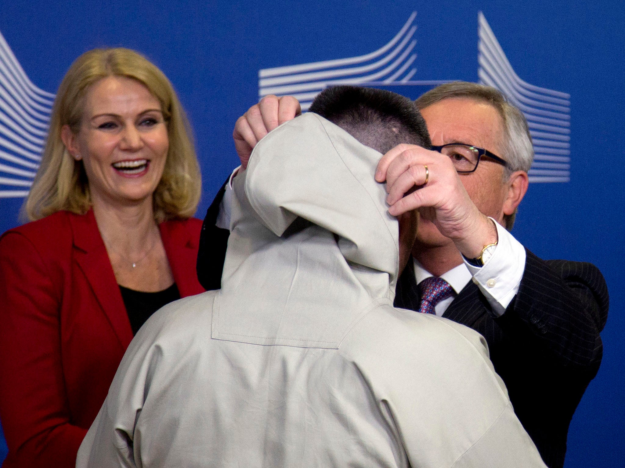 Helle Thorning-Schmidt looks on as Jean-Claude Juncker adjusts Kim Kielsen’s ‘hood’