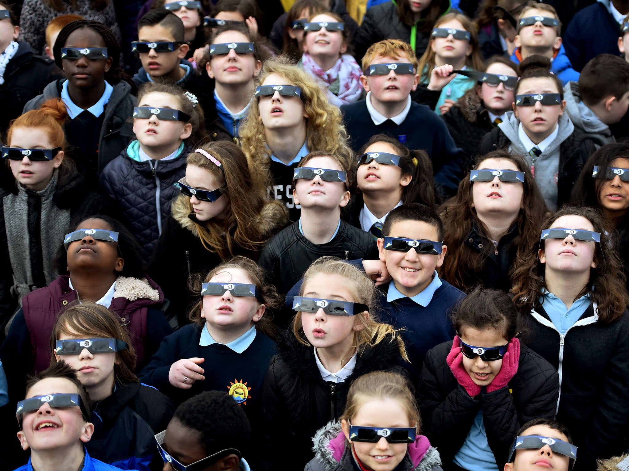 Glasgow school children use special glasses to look into the sky at a partial solar eclipse