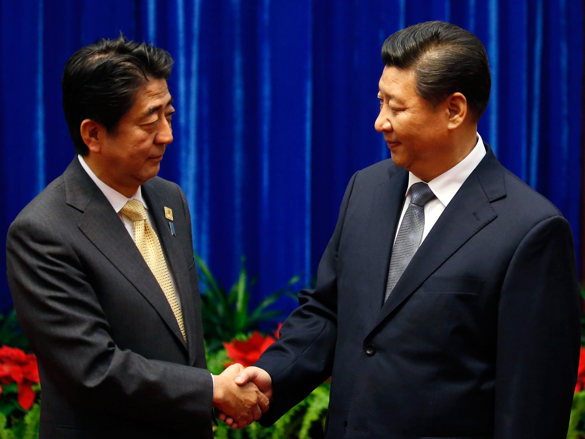 President Xi Jinping of China and Prime Minister Shinzo Abe of Japan shake hands