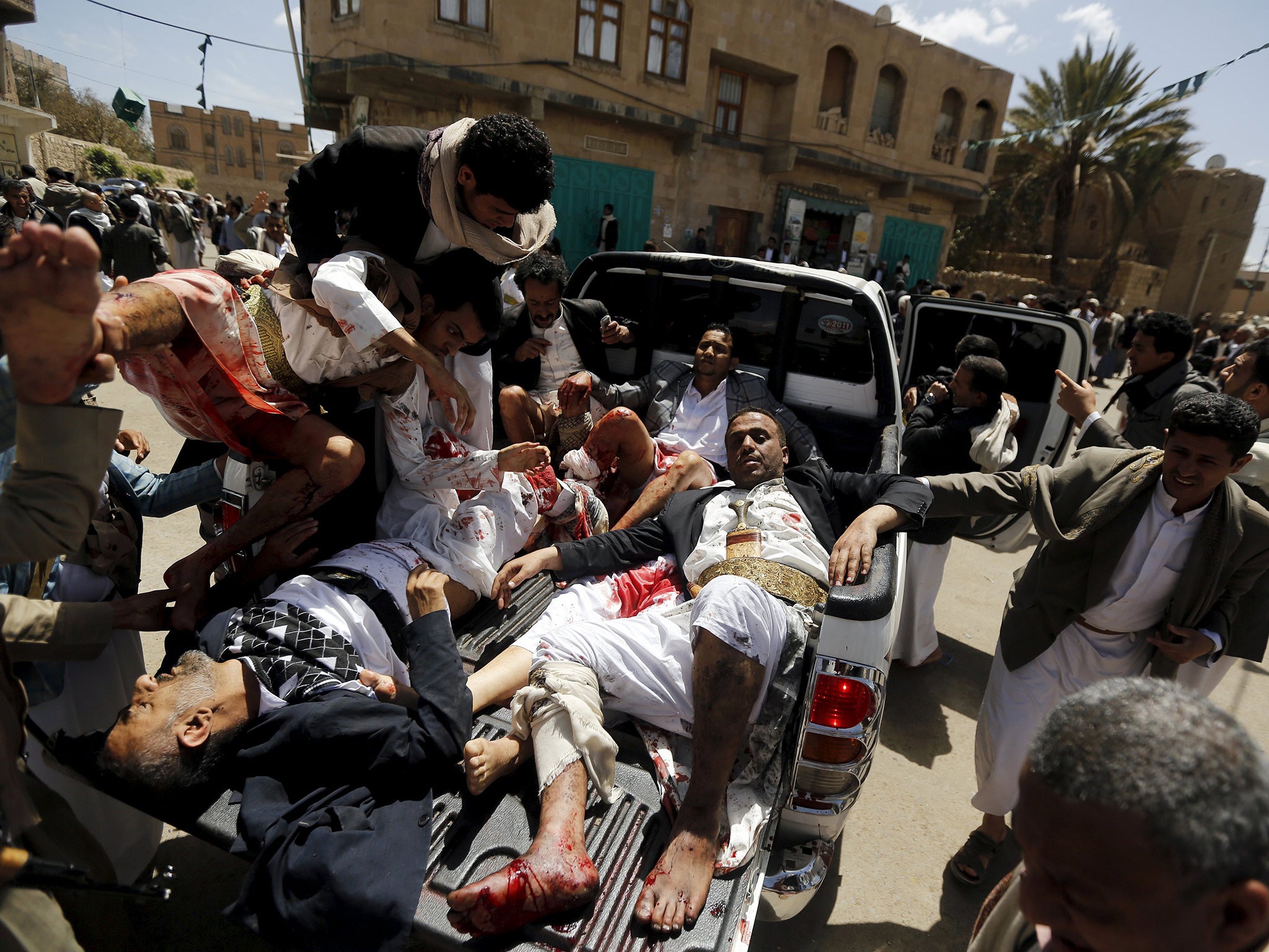 Injured worshippers are carried on to a truck to be rushed to hospital in Sanaa