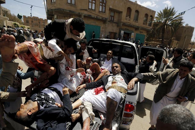 Injured worshippers are carried on to a truck to be rushed to hospital in Sanaa