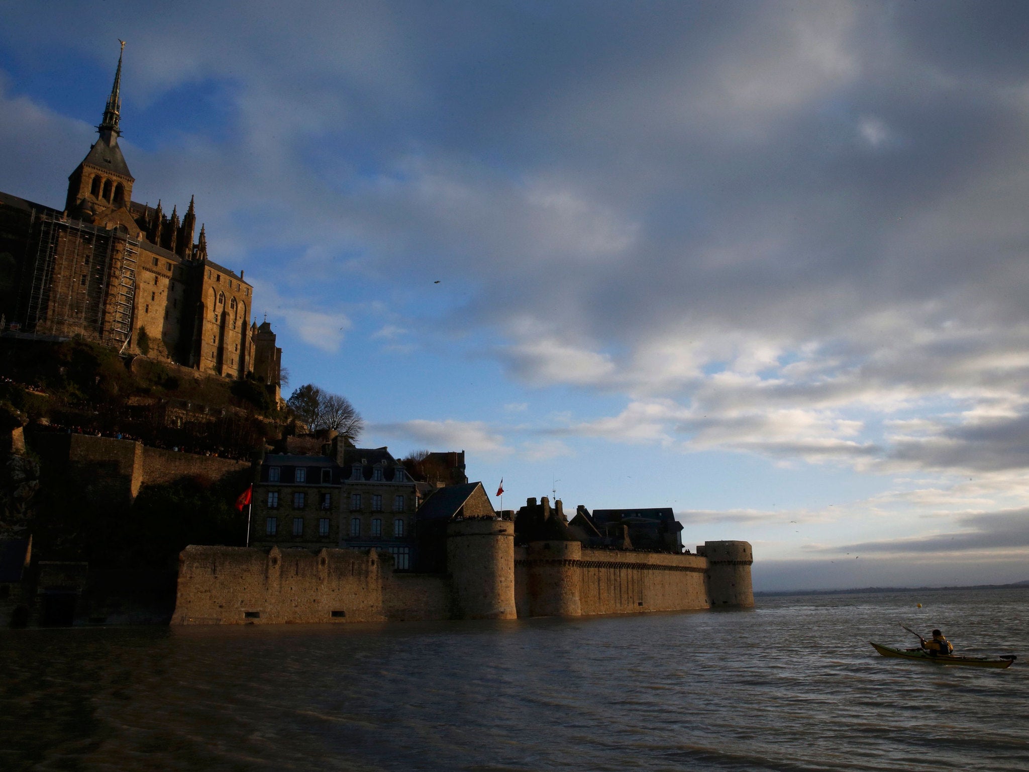 A man canoes around Mont Saint-Michel in France during the record 'supertides' following hte solar eclipse